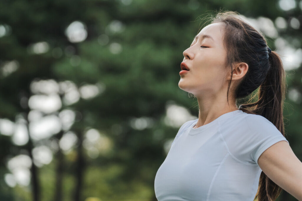 There is a woman who feels good and breathes deeply after a treatment of the nasal problem.